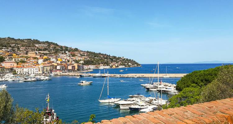 Een haven met jachten en een kustplaats.