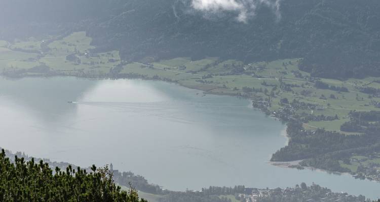 Luchtfoto van een meer omgeven door velden en heuvels.