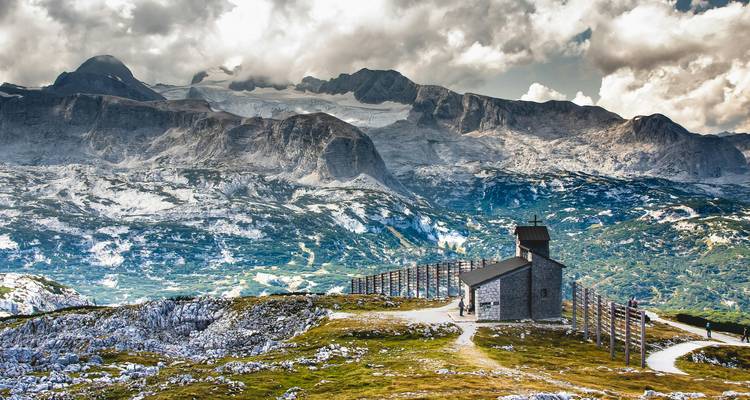 Bergachtig uitzicht met een kleine kapel op een heuveltop.