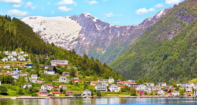Charmant village au bord du fjord aux maisons colorées, dominé par d'escarpées montagnes verdoyantes et un pic enneigé