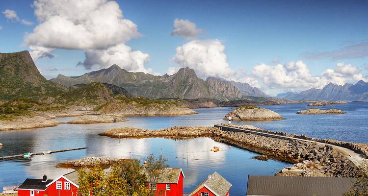 Paysage côtier pittoresque avec des maisons rouges et des rivages rocheux.