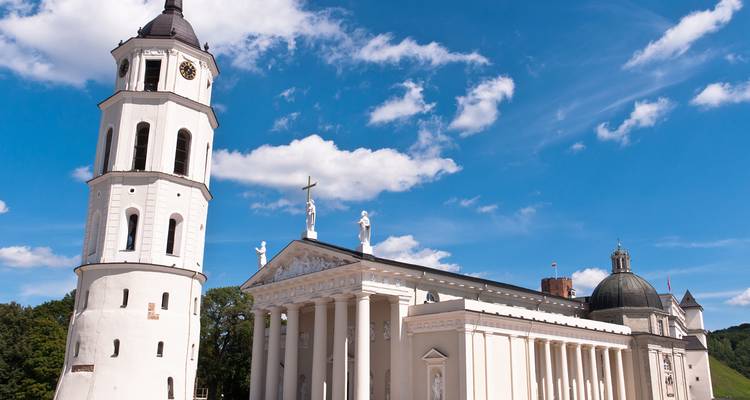 Basilique-cathédrale de Vilnius avec son clocher sous un ciel bleu.