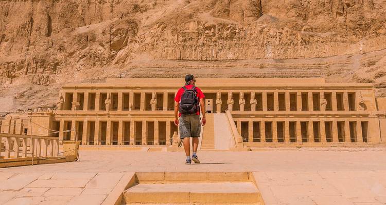 Un visiteur se dirigeant vers le grand Temple d'Hatshepsout taillé dans les falaises calcaires de Louxor.