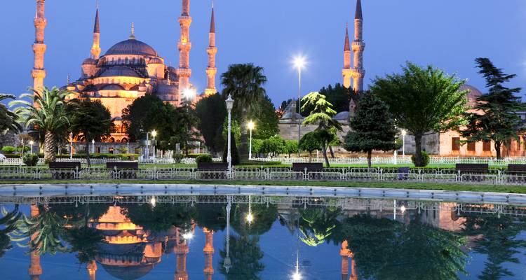 Blaue Moschee bei Nacht beleuchtet mit Spiegelung in einem Teich.