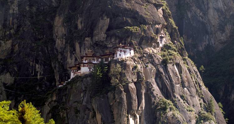 Le monastère du Nid du Tigre accroché à une falaise abrupte au milieu de montagnes escarpées.
