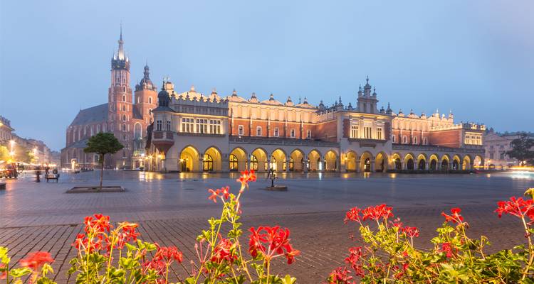 Town hall and square in Krakow illuminated at dusk.