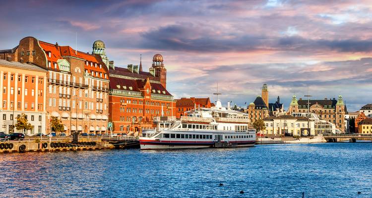 Scenic view of Stockholm waterfront with colorful buildings and a boat.