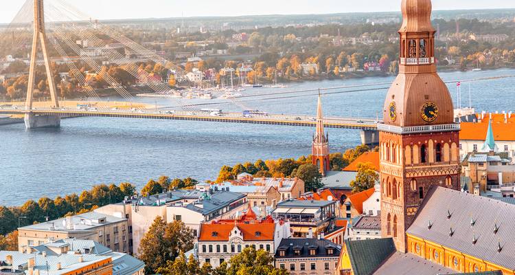 View of Riga cityscape with a prominent church tower and bridge.
