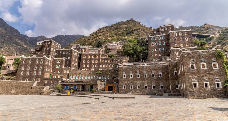 Traditional stone buildings situated in a mountainous area.