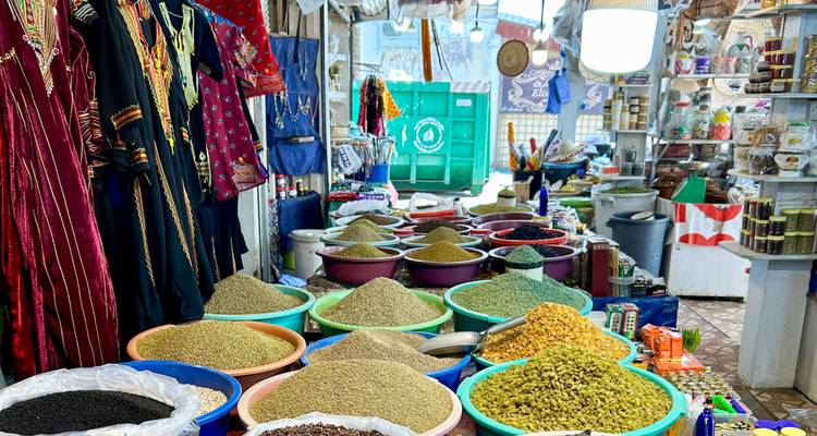 Market scene with spices and traditional clothing.