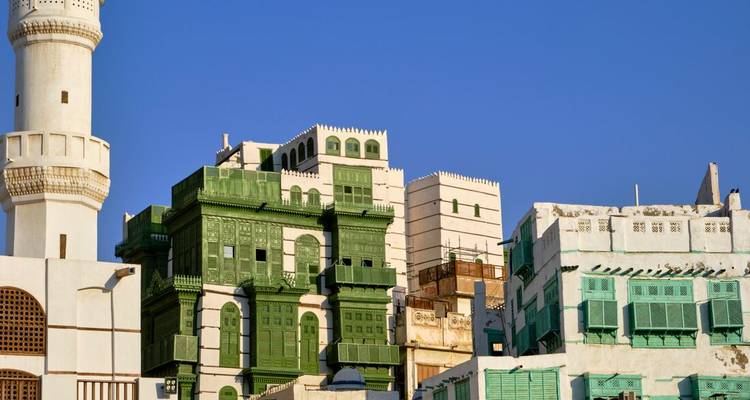 Traditional buildings with green details against a clear blue sky.