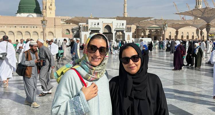 Two women posing happily in a large open courtyard.