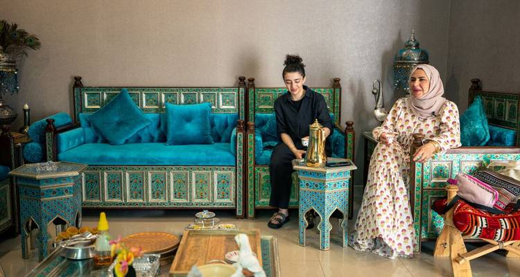 Deux femmes dans un salon décoré de manière traditionnelle.