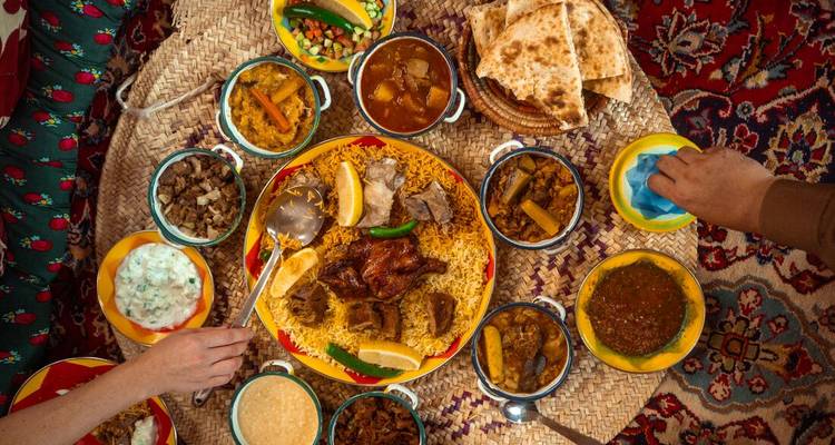 Repas traditionnel du Moyen-Orient étalé sur une natte tissée.