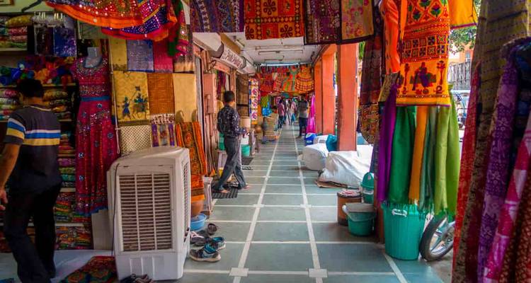 Een kleurrijke marktstraat met kleding en textiel.