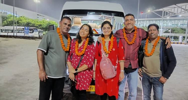 Gruppe von sechs Personen, die nachts in der Nähe eines Reisebusses posieren.