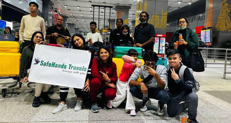 Gruppe von Reisenden mit einem Banner an einem internationalen Flughafen.