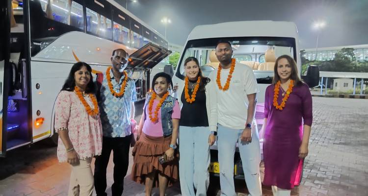 Gruppe von Touristen, die nachts vor einem Reisebus posieren.