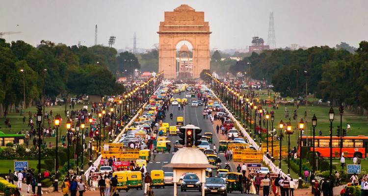 Porte de l'Inde à New Delhi avec une route très fréquentée remplie de gens et de véhicules.