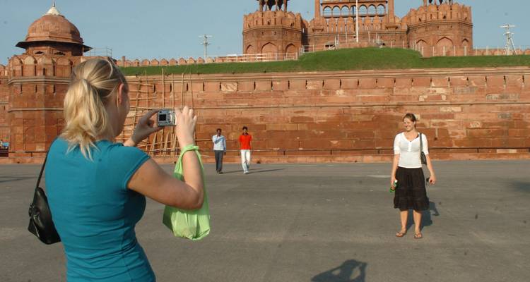 Des touristes se photographiant mutuellement devant un fort historique indien.