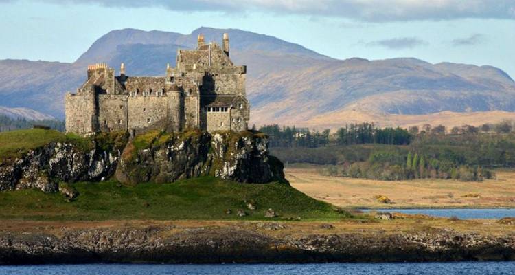 Château historique situé sur une colline rocheuse surplombant la mer.