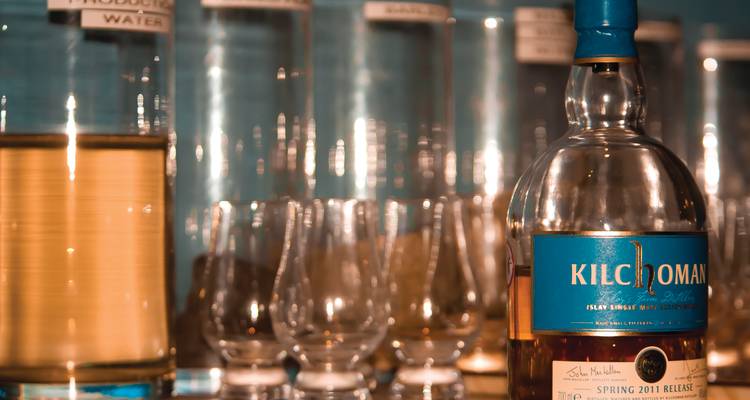 Bouteille de whiskey et verres exposés sur une étagère.