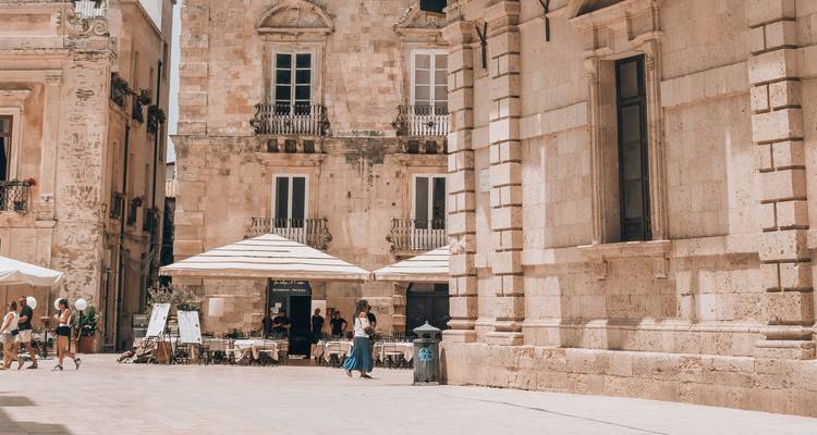 Rue de ville européenne avec bâtiments historiques et café.
