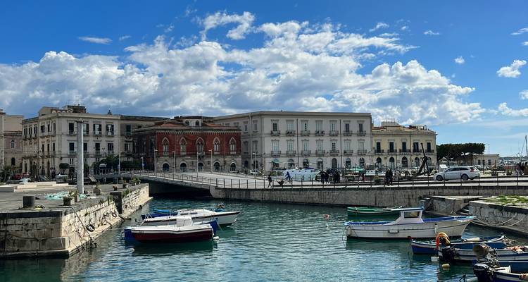 Bateaux amarrés dans un port avec des bâtiments historiques en arrière-plan.