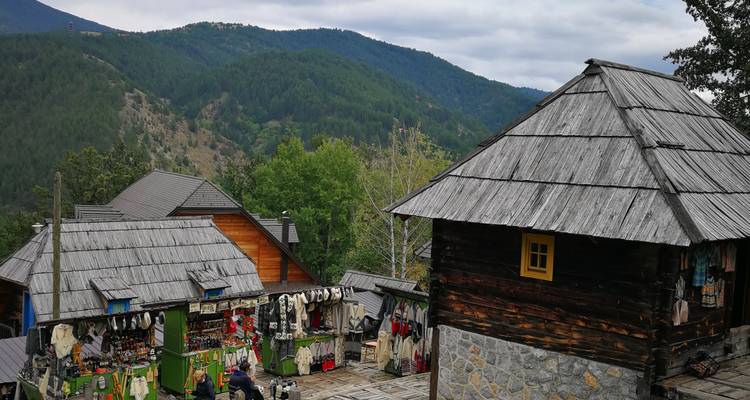 Village de montagne avec maisons en bois et étals de marché.