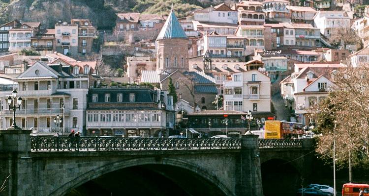 Vue de Tbilissi avec architecture traditionnelle et pont.