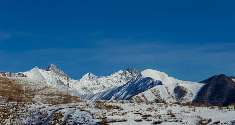 Sommets de montagnes enneigés avec un ciel bleu clair.