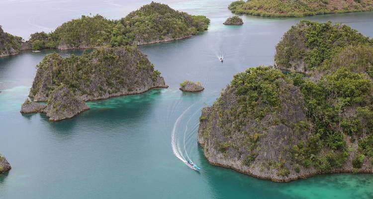 Vista panorámica de islas con barcos dejando una estela en el agua.