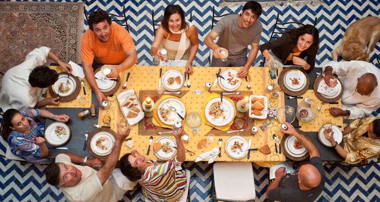 Des personnes assises à une table à manger savourant un repas vu de haut.