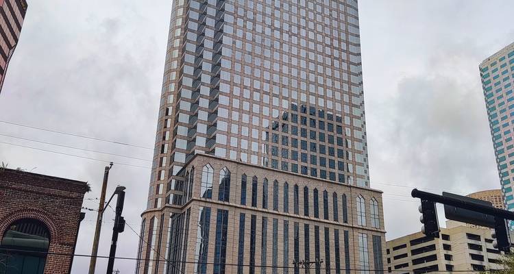 Wolkenkratzer in städtischer Umgebung mit bewölktem Himmel.