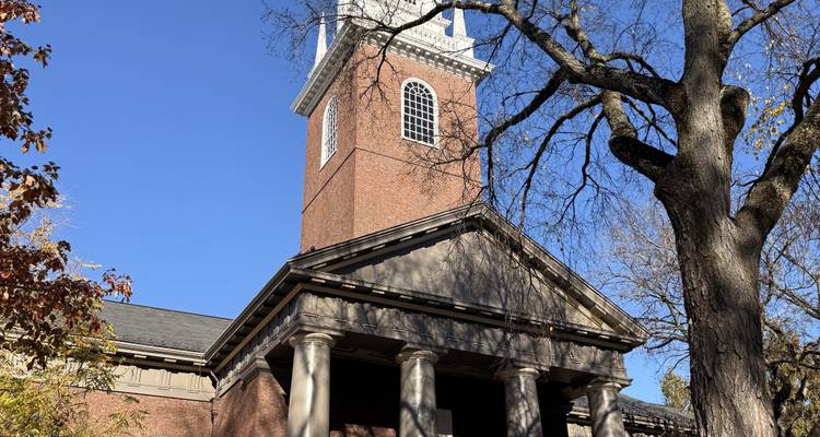 Une église historique en briques rouges avec un haut clocher.