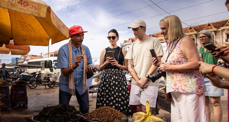 Scène de marché avec des touristes observant les spécialités locales.