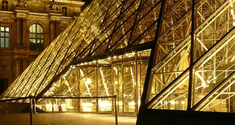 La pyramide de verre illuminée du Louvre la nuit.