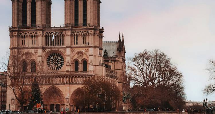 La façade de la cathédrale Notre-Dame avec des personnes au premier plan.