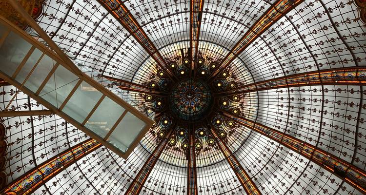 Plafond en verre orné dans un bâtiment historique.