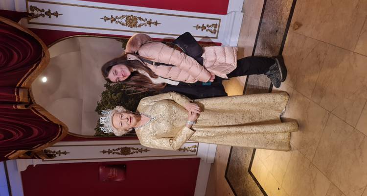 Personne posant avec une figure de cire d'une reine.