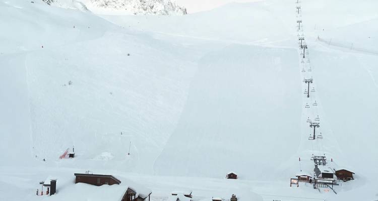 Piste de ski vide couverte de neige avec téléphérique.