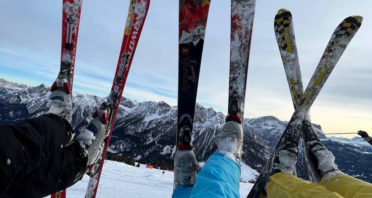 Plusieurs skieurs se reposant avec leurs skis croisés.