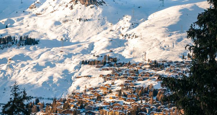 Village enneigé sur un versant de montagne ensoleillé.