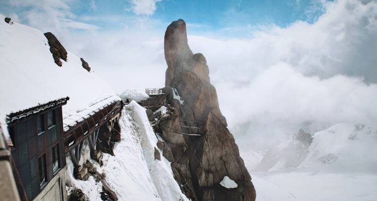 Pic rocheux enveloppé de brume et de neige.
