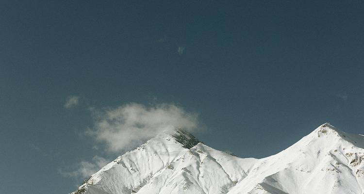 Pic de montagne enneigé avec ciel bleu.