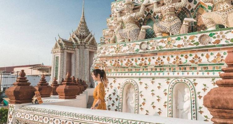 Une personne à côté d'une décoration de temple ornée.