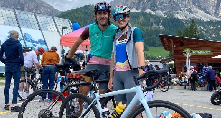 Cyclists gathered outside a building in a mountainous area.