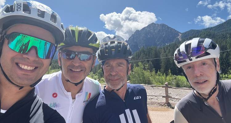 Group of cyclists taking a selfie with mountains in the background.