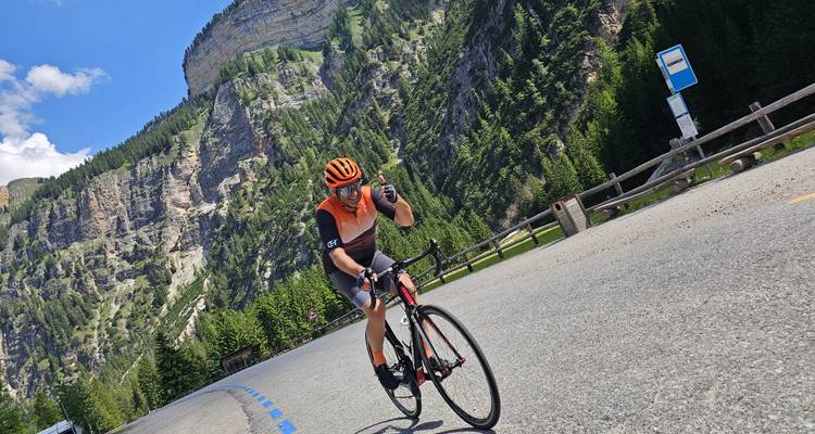Cyclist taking a break on the side of a mountain road.