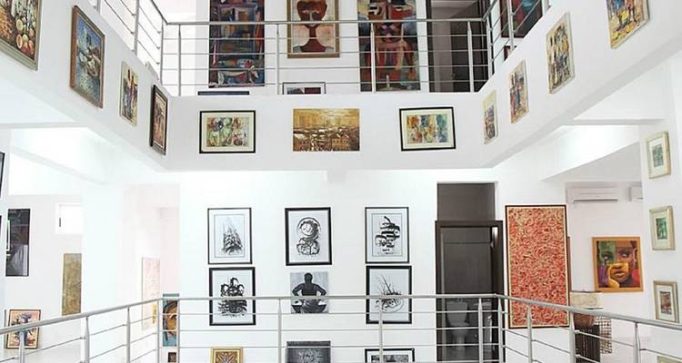 Art gallery interior with various framed artworks on display.